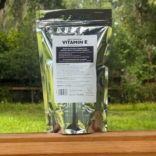 Vitamin E supplement package on a wooden surface with a natural background