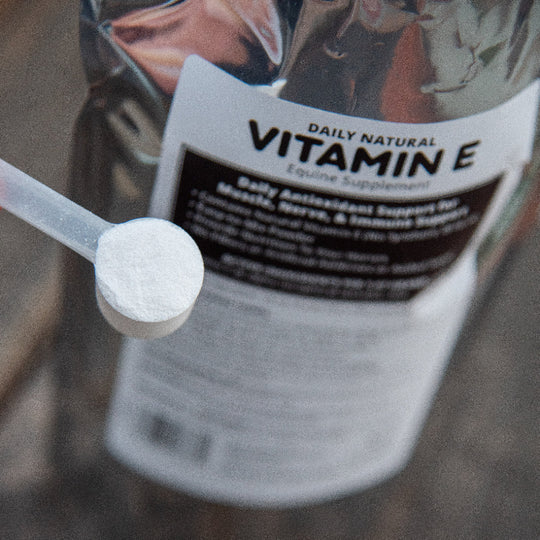 Vitamin E supplement scoop on a wooden surface